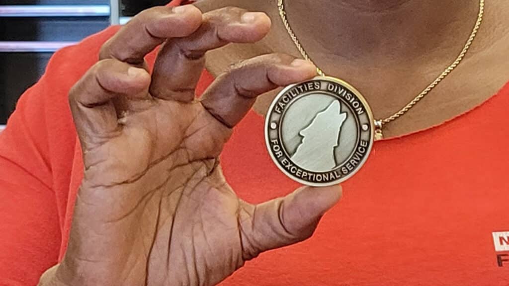 Close-up of Leggett's hand holding the coin