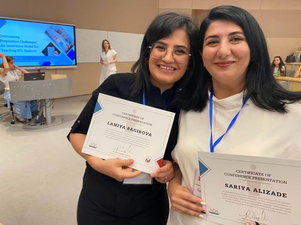 Two women hold certificates for completing the program