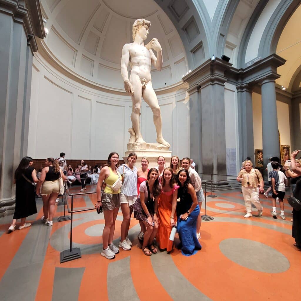 Students pose with the Statue of David in Florence