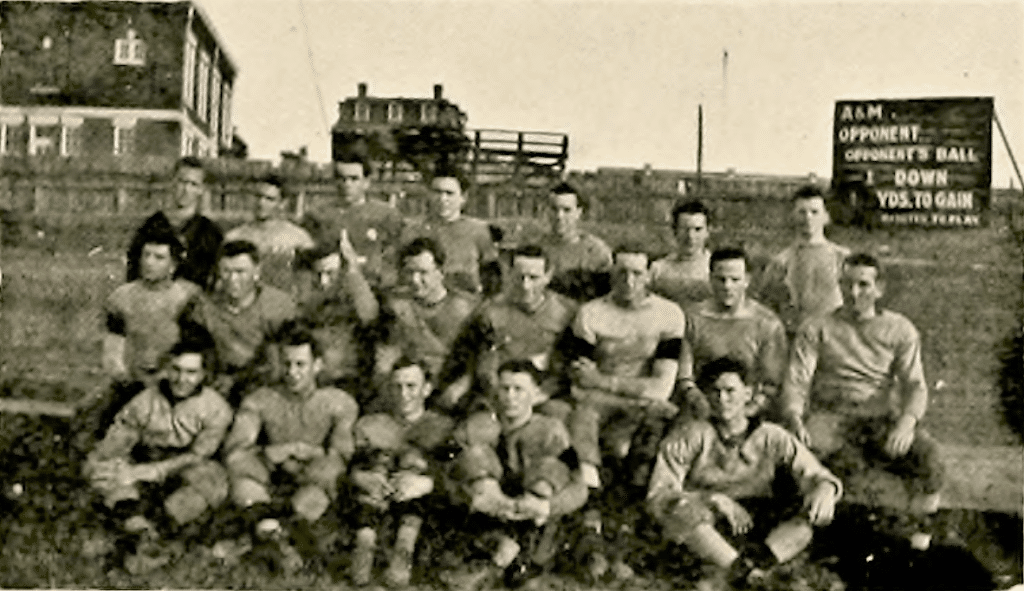 NC State's football team in 1913, with the wooden scoreboard visible in the background.