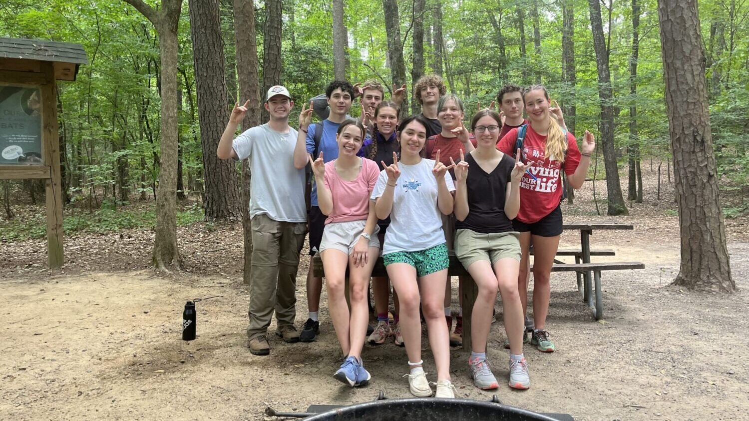Incoming University Honors Program students in a group photo in a wooded area.