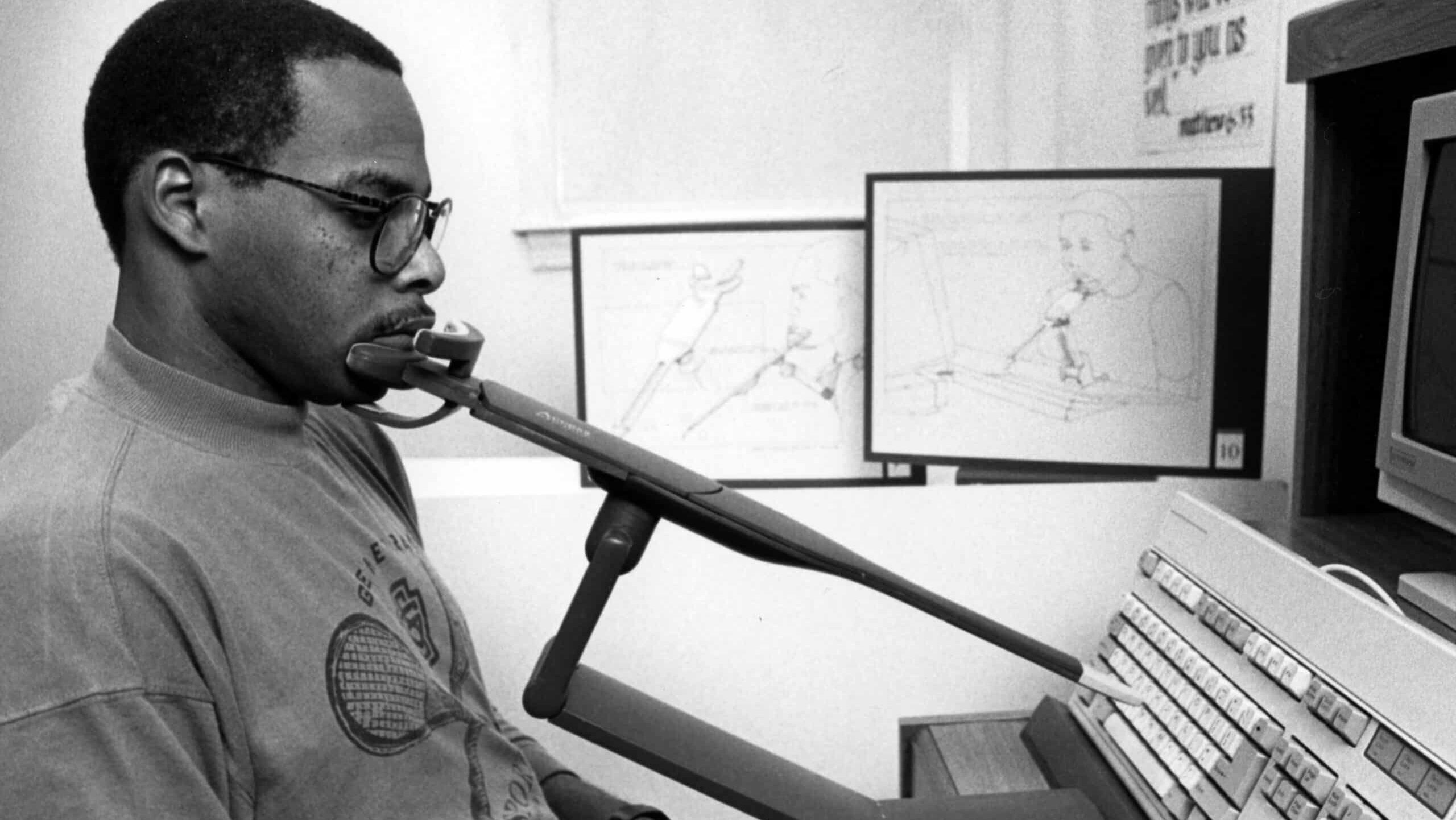 Graduate student Vincent L. Haley demonstrating his pointer device for computer accessibility, circa 1980 to 1989.