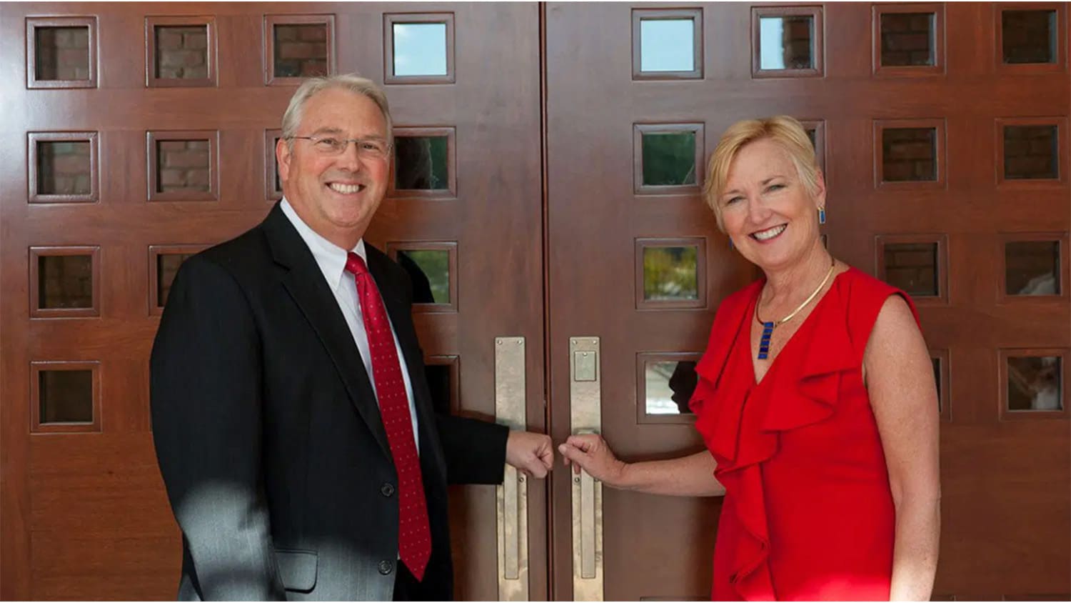 Chancellor Randy Woodson and his wife, Susan, holding the handles to the front door of their house