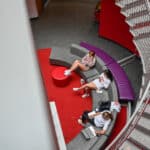 Three students sit on a curved couch in Talley Student Union, seen from above.