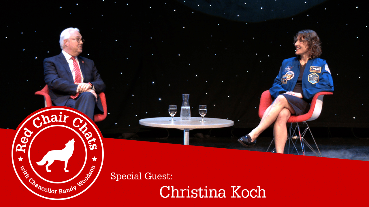 Chancellor Woodson and NASA astronaut Christina Koch sit on stage at Stewart Theatre with a starry background behind them. The image also contains the Red Chair Chats graphic, which says "Red Chair Chats with Chancellor Woodson. Special guest: Christina Koch"