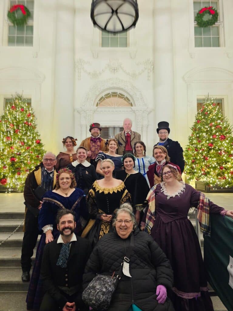 The full Oakwood Waits group in front of two Christmas trees at the White House