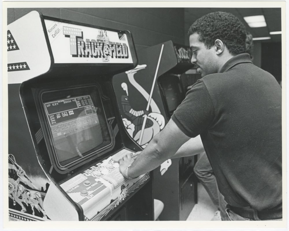 A student plays a classic arcade game called Track and Field, circa 1984