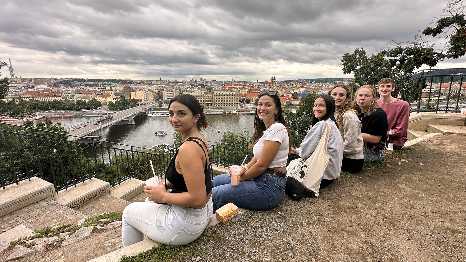 A row of NC State students sit overlooking the skyline of Prague, Czechia.