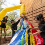 Three students set up colorful balloons to display at the Gregg Museum of Art and Design's Inflatable Contemporary Art exhibition.