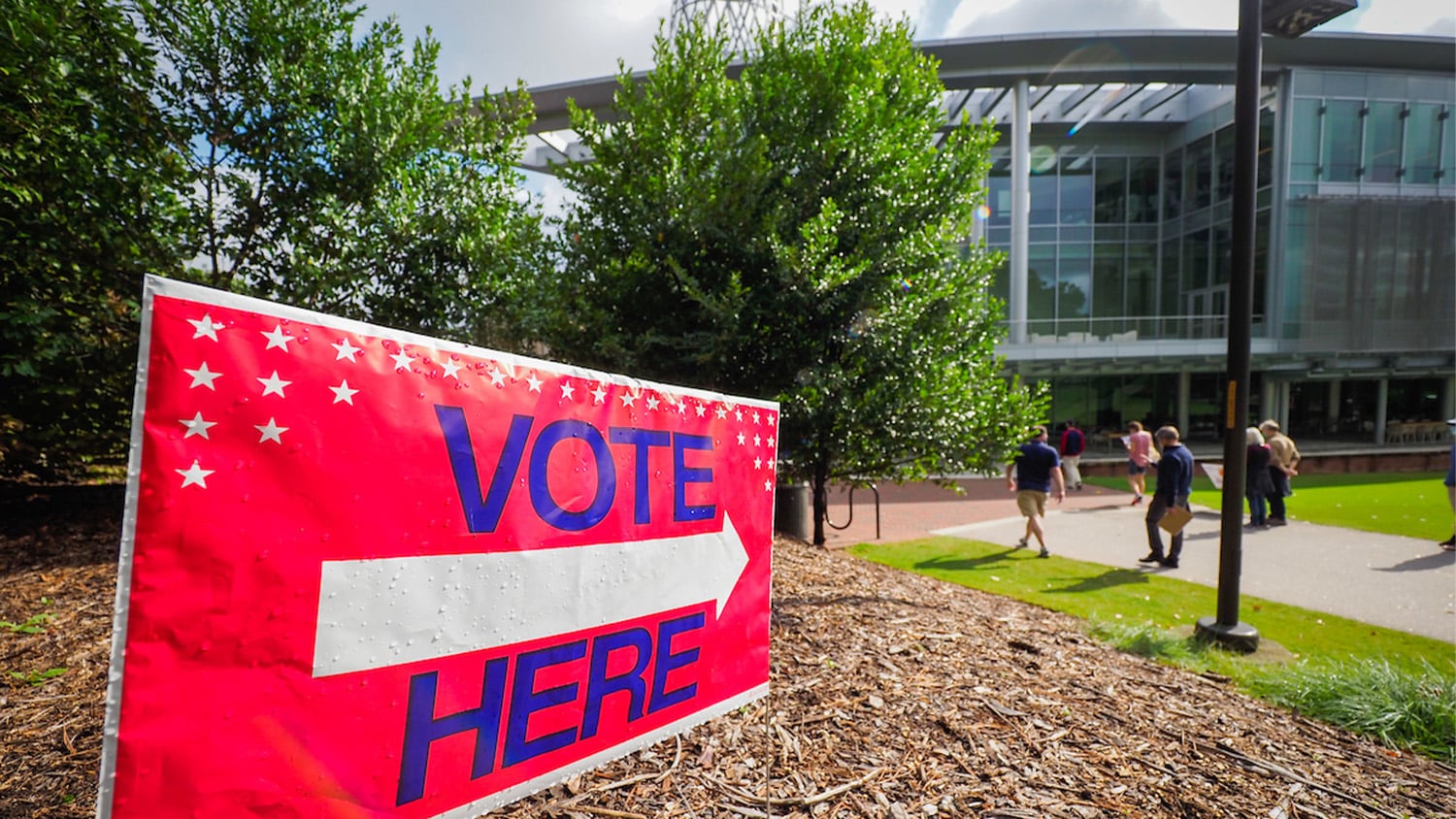 A red, white and blue sign reads "VOTE HERE" and points to Talley Student Union.