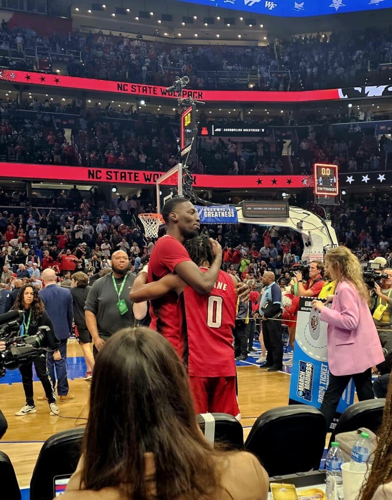 DJ Horne and a teammate embrace on the court after the game