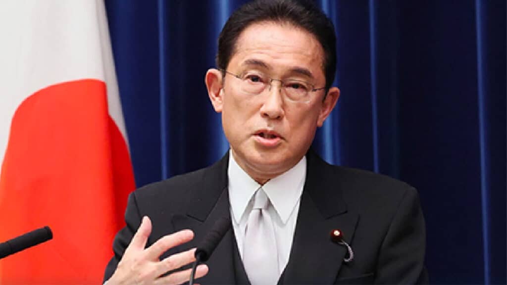 Japan's prime minister Fumio Kishida gives a press conference in front of a Japanese flag.