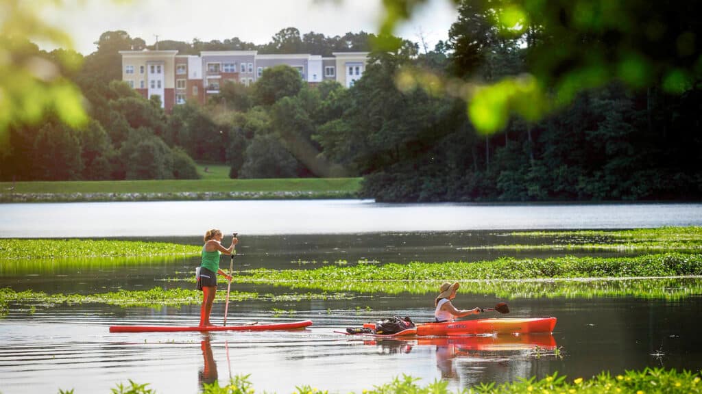 Two people enjoy water activities on Lake Raleigh.