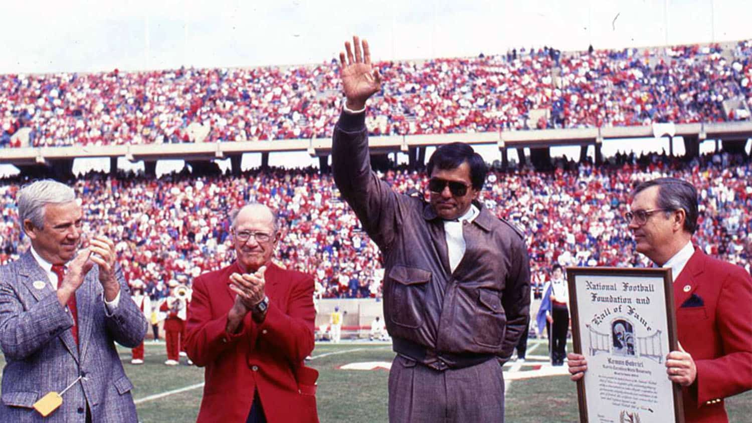 Roman Gabriel waves to the crowd during his induction into the College Football Hall of Fame