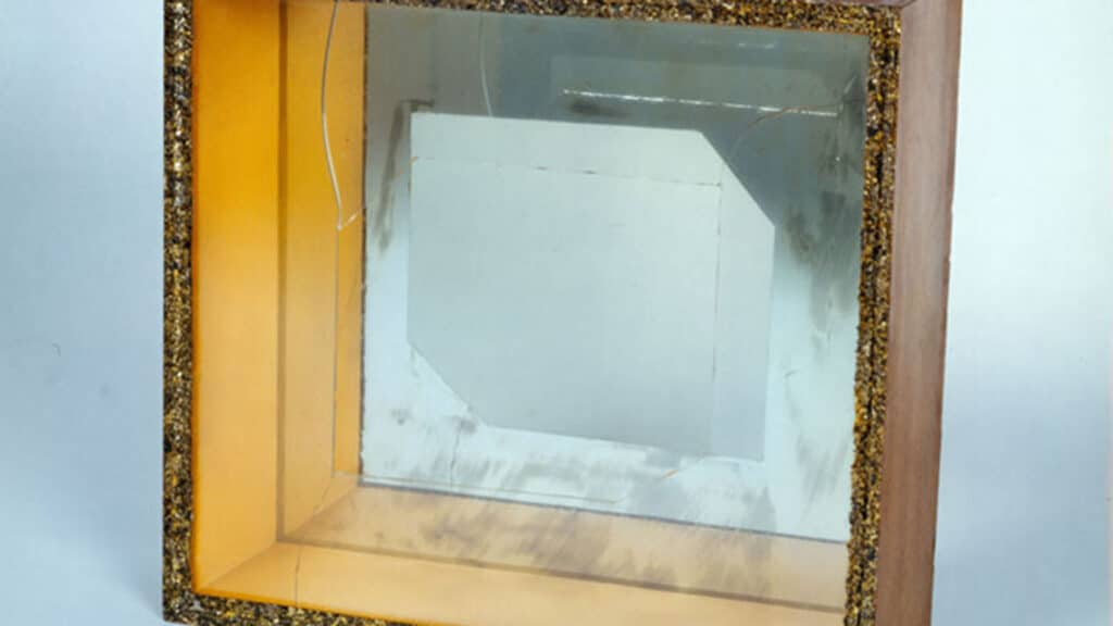 A front-on view of a shadow box with glass fractured in the front.