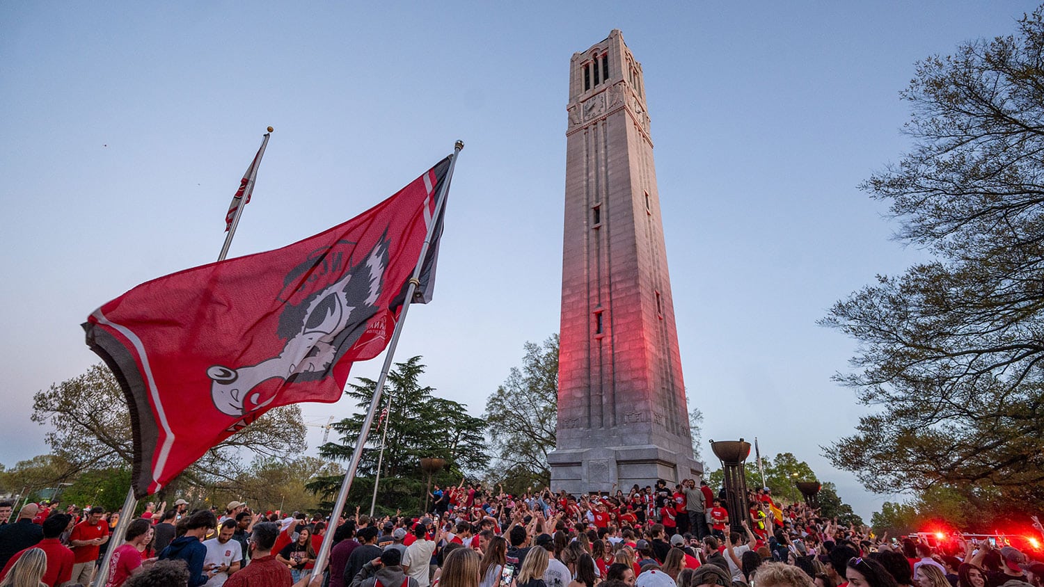 With the Wolfpack men's and women's basketball teams scoring major 2024 NCAA Championships wins, crowds of fans gather to celebrate at the Memorial Belltower.