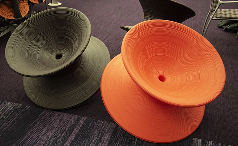 Two spinner chairs, one dark green and one orange.