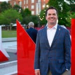 Jude DesNoyer, a leader of innovation and community engagement for NC State and Centennial Campus, smiles at a dedication event for the Susan Woodson Plaza.