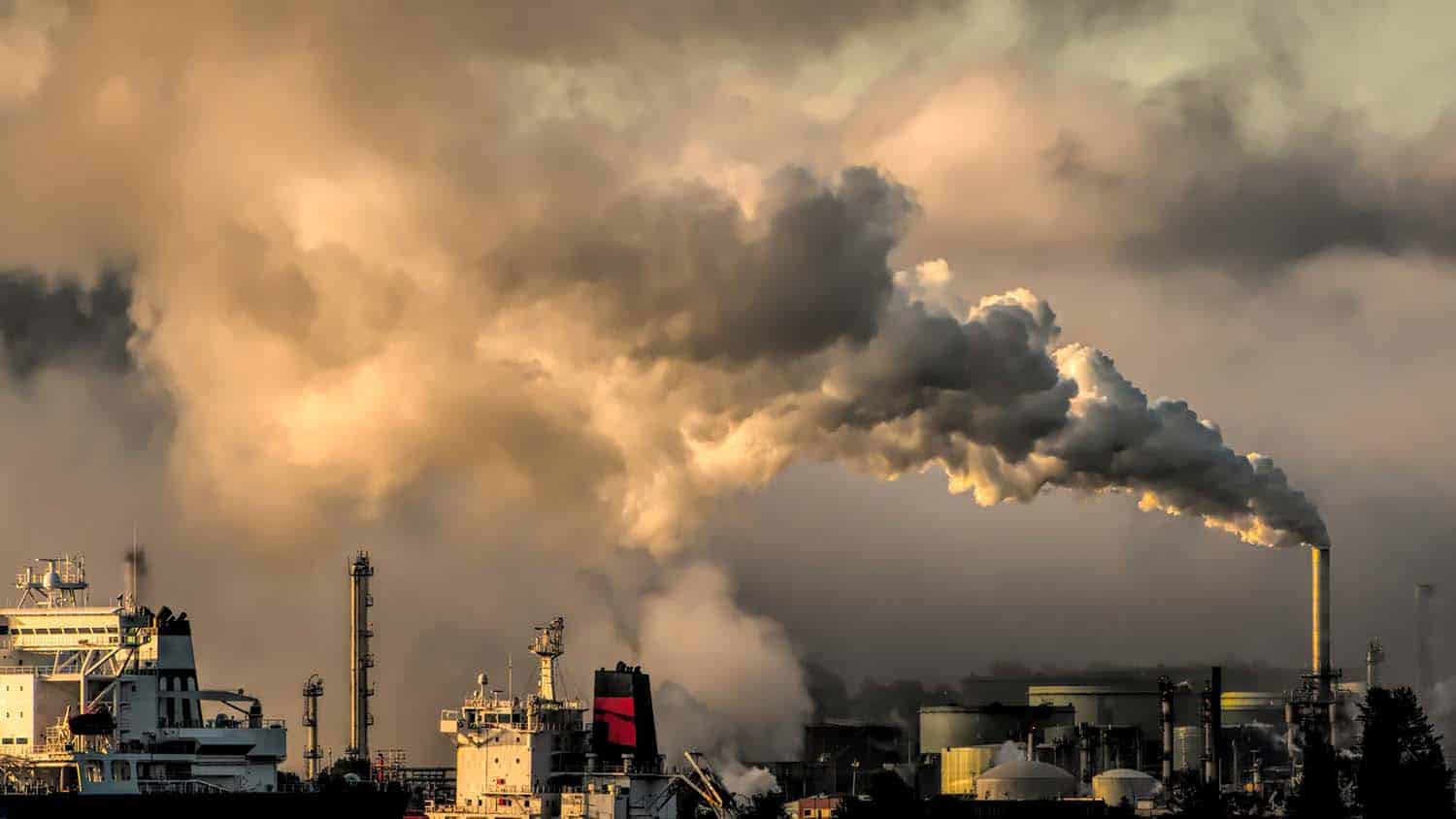 photo of an industrial landscape with large smokestacks billowing white clouds