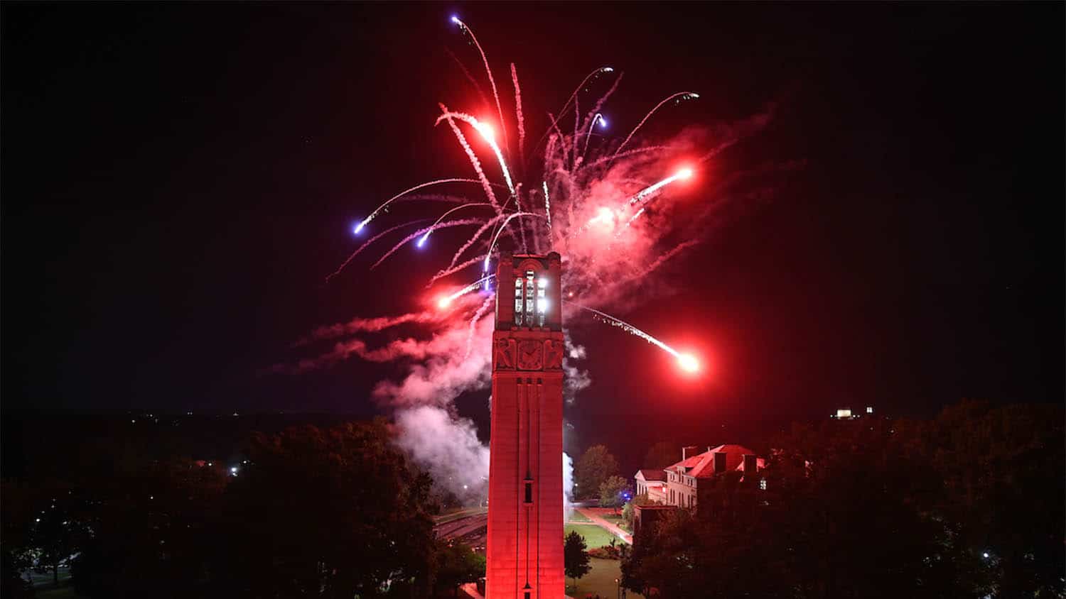 Red fireworks go off over the Belltower