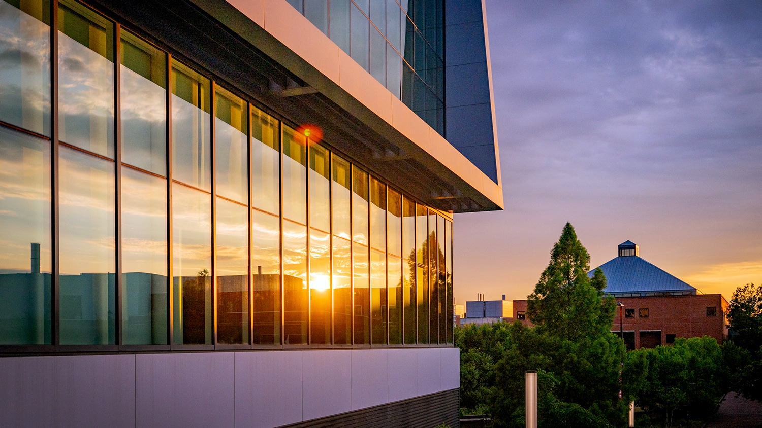 The setting sun reflects off the windows at Hunt Library.