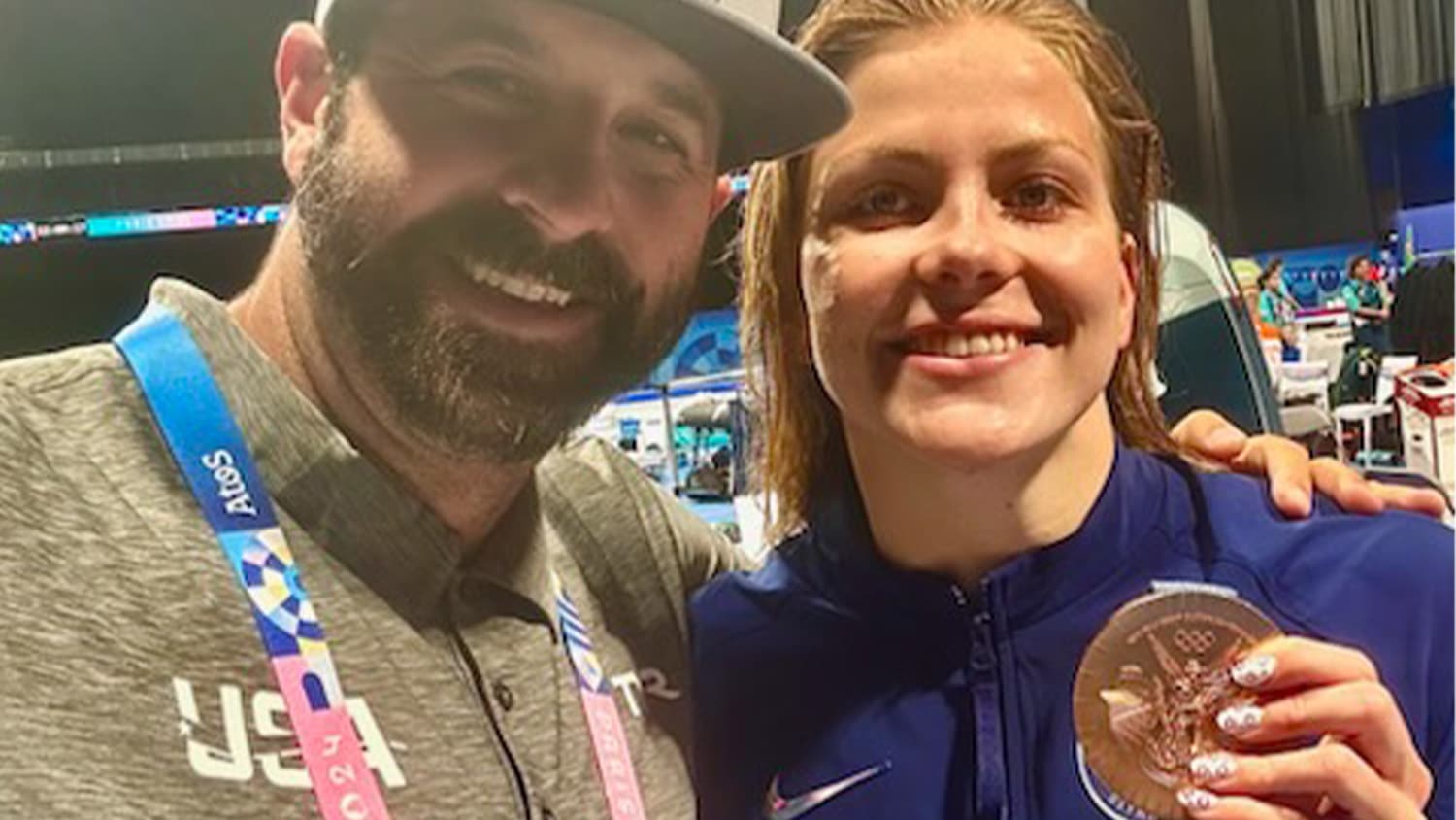 Swimmer Katharine Berkoff and NC State men's and women's swimming Coach Braden Holloway take a selfie after Berkoff won a gold medal at the 2024 Olympics