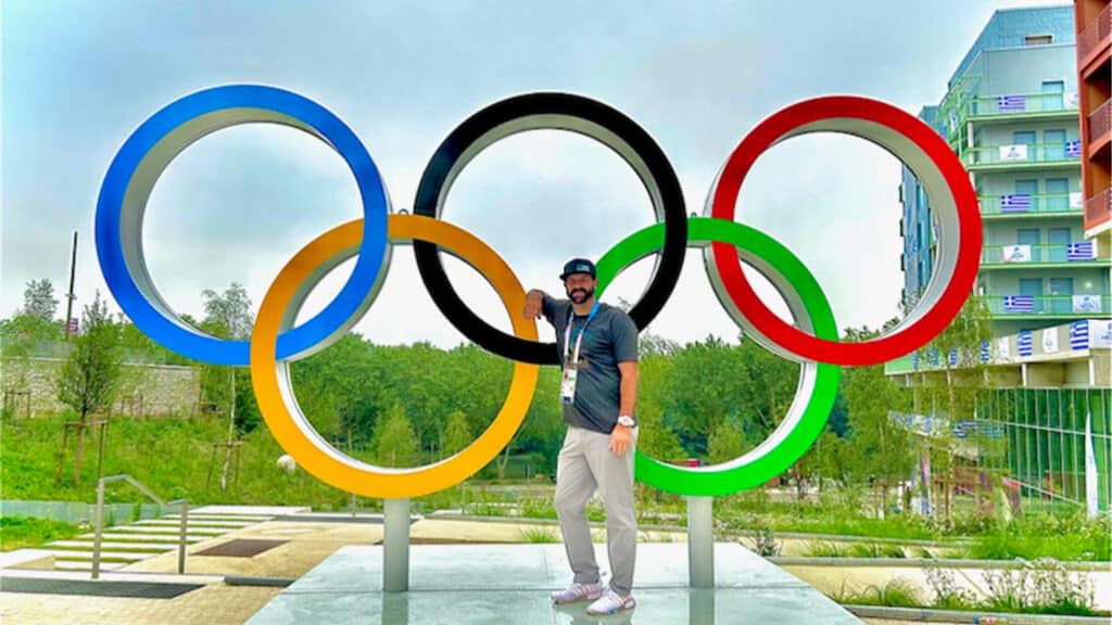 Holloway poses in front of a large statue depicting the Olympic rings logo.