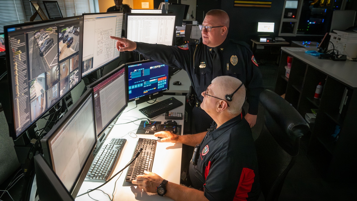 NC State Chief of Police Dan House and an NC State staffer work together at an information station within the university's Resiliency Operations Center.