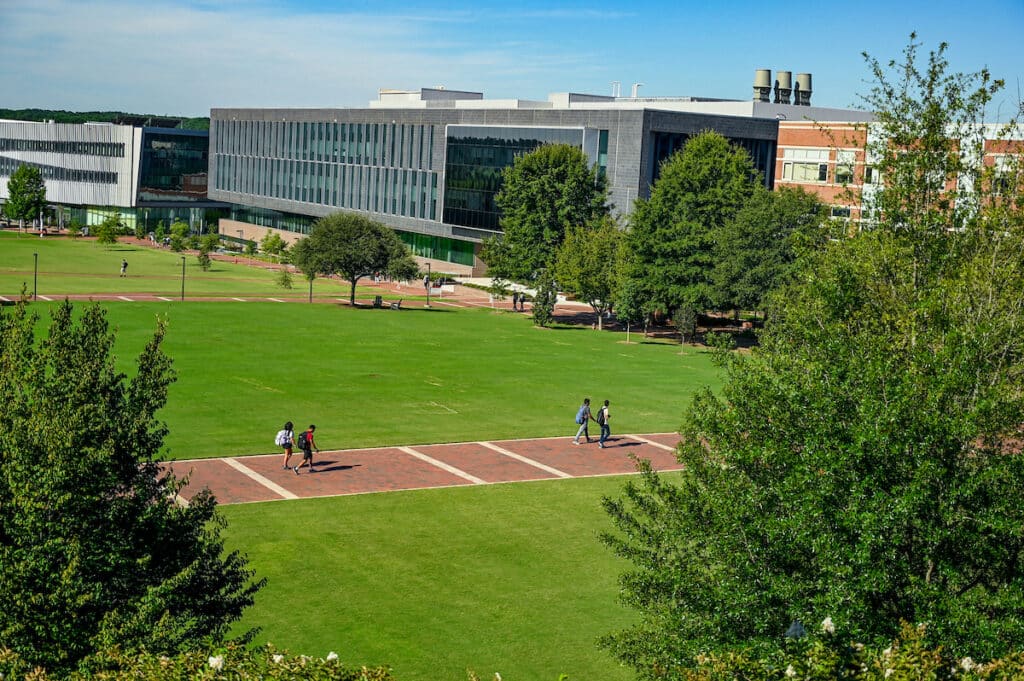 Students walk on the brick path in the middle of the Oval 