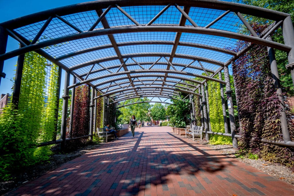 A student walks through the archway at the Governors Scott Courtyard