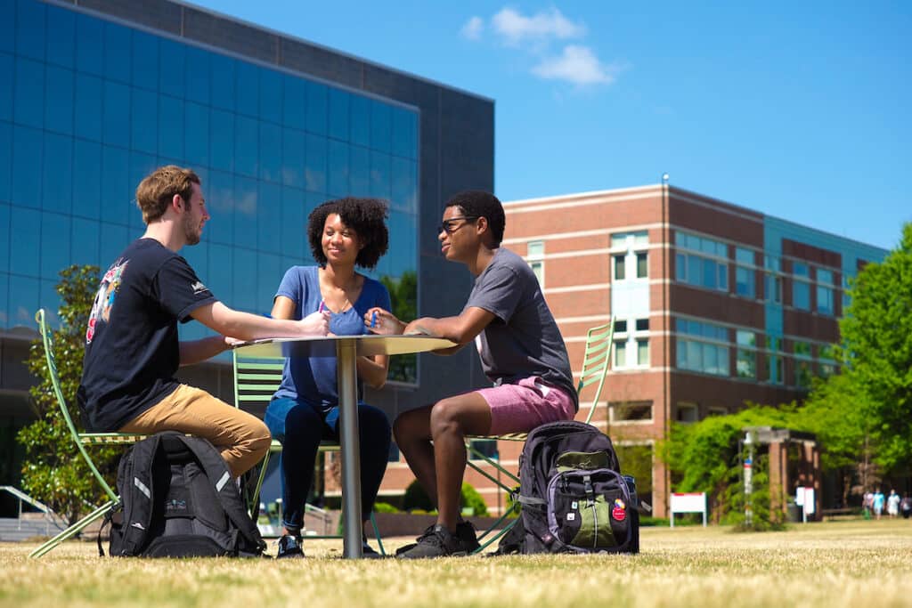 Students work together at a table on the Oval