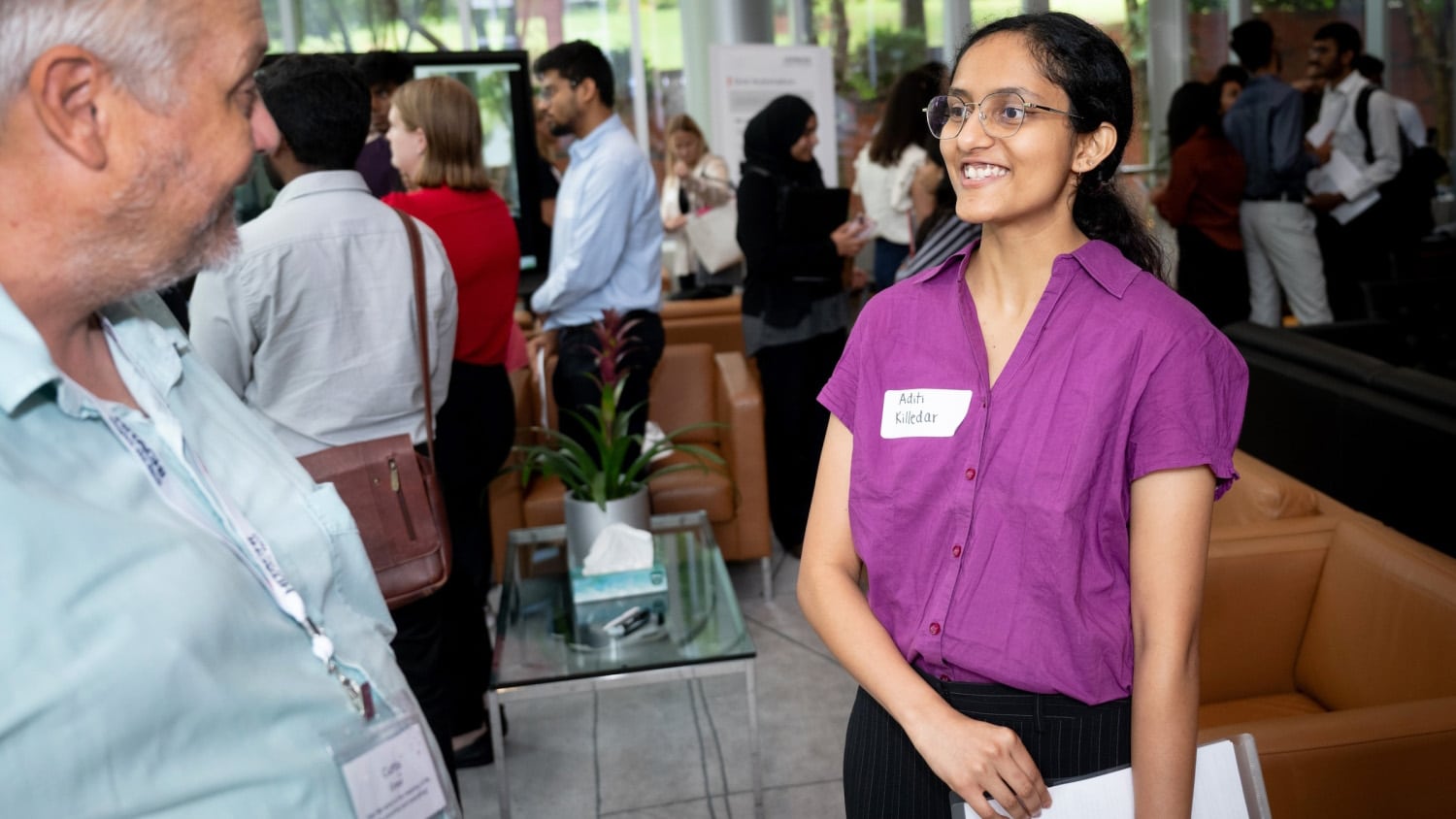 A student talks with a Hitachi employee at a career fair