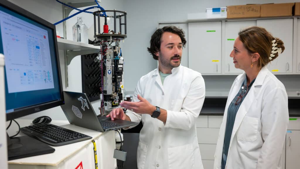 Graduate student Will McClure and research technician Barrett Rose working with the Imaging Flow Cytobot device.