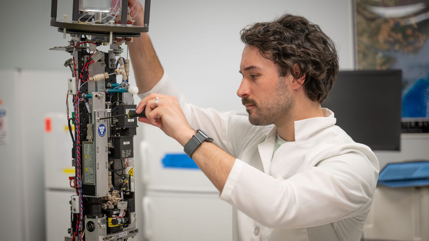 Graduate student Will McClure works on the Imaging Flow Cytobot device.