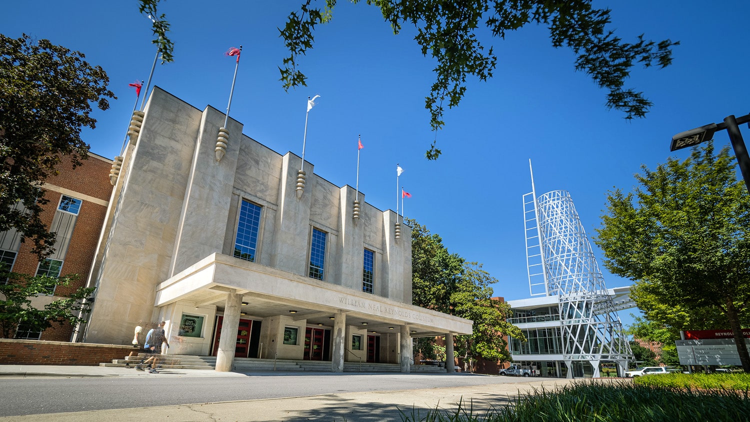 The exterior of Reynolds Coliseum and Talley's technology tower during the day