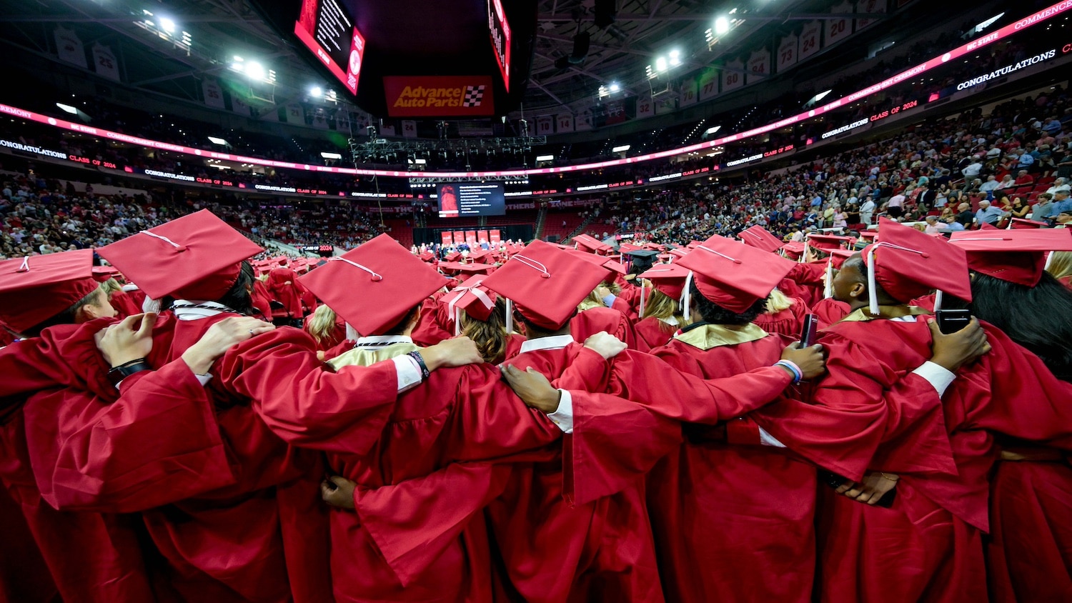 Graduates wrap their arms around each other at the commencement ceremony