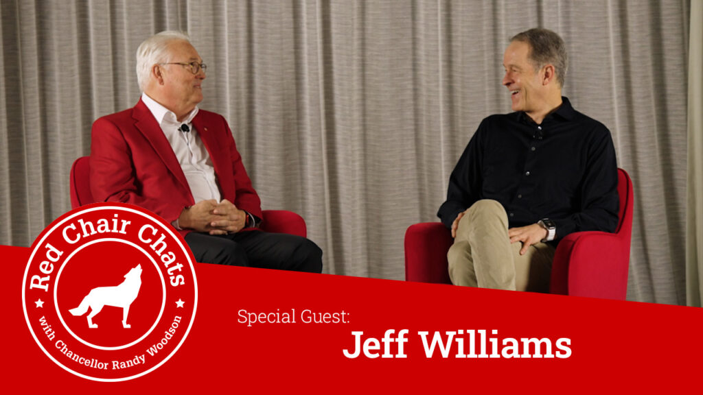 Chancellor Woodson and Jeff Williams sit on stage in red chairs. A graphic with the Red Chair Chats logo says "Red Chair Chats with Chancellor Woodson, Special Guest Jeff Williams"