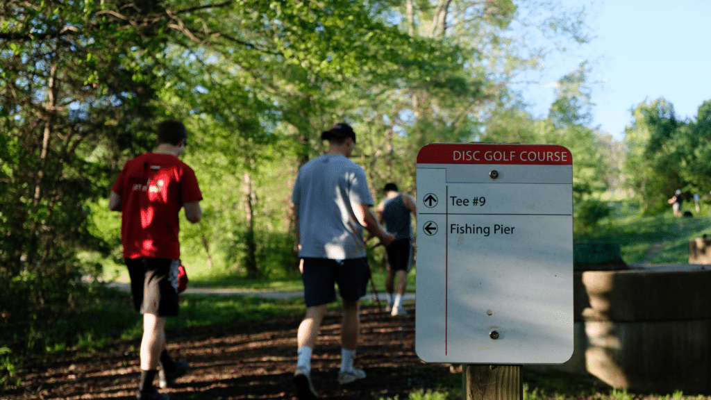 Students walk toward the next tee on the disc golf course.