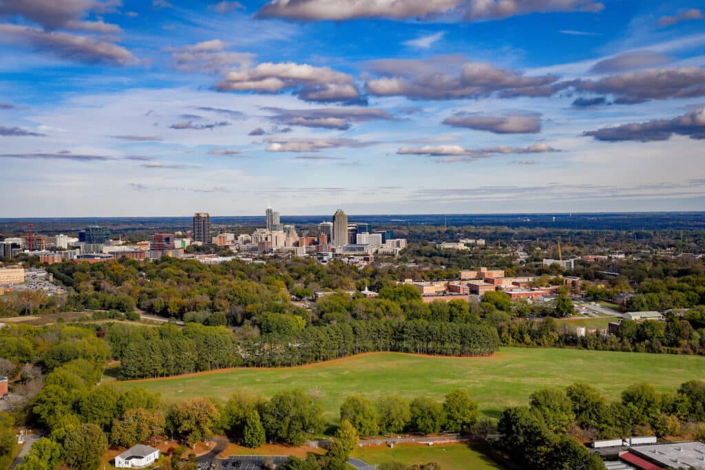 An aerial view of the Lonnie Poole Golf Course on Centennial Campus, with downtown Raleigh in the distance.