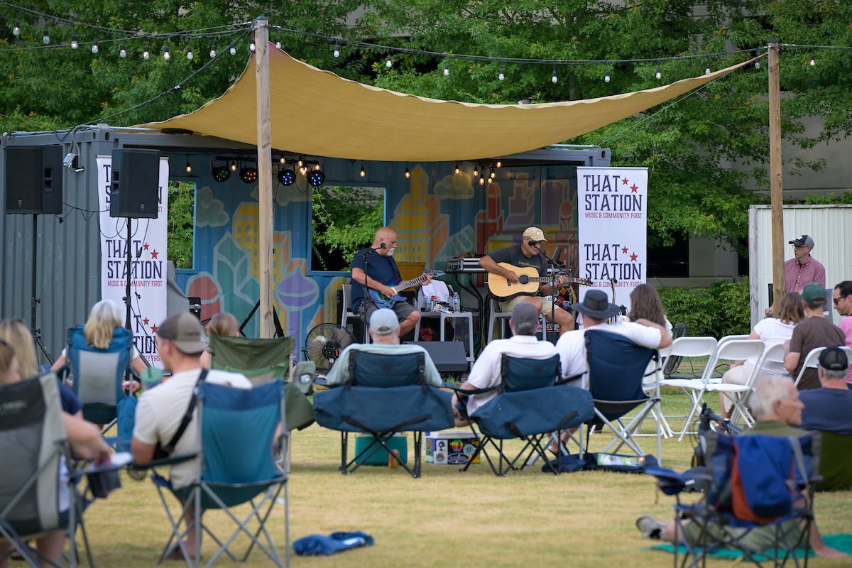 People sit in lawn chairs and watch an Artist Notes performance at Centennial Campus.