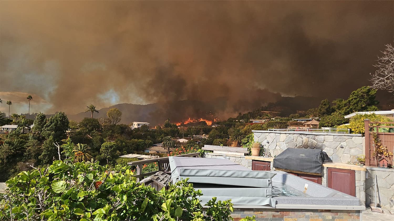 Dark, billowing smoke covers a neighborhood near the Palisades.