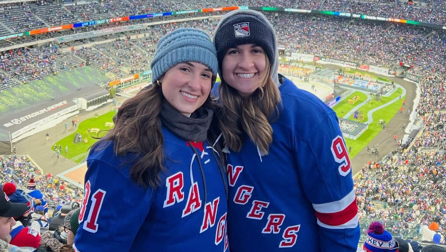 Elaine and Allyson Wolochuck pose for a photo wearing NY Rangers jerseys at a stadium.