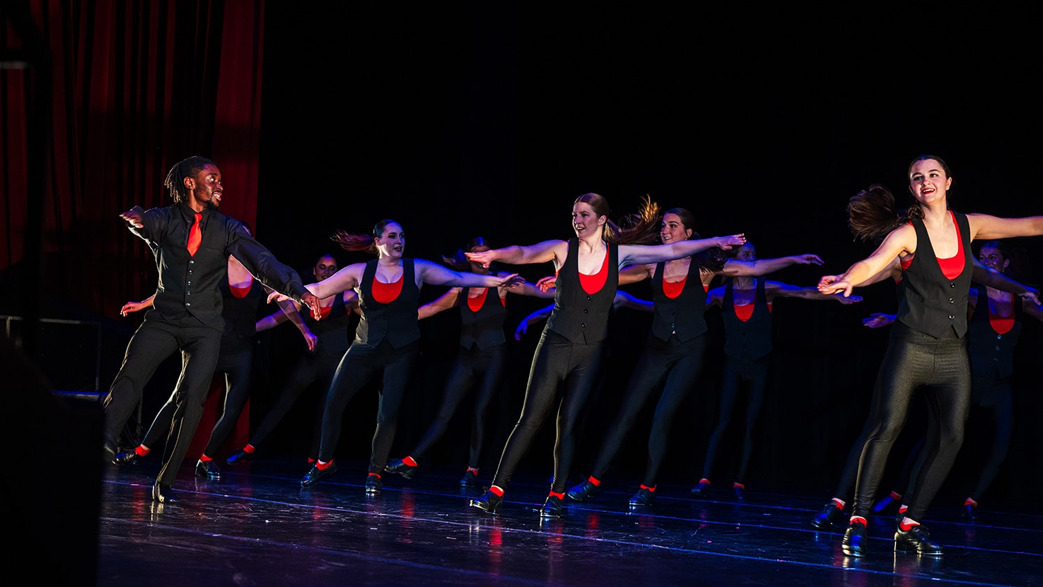 A group of students dance on stage at Stewart Theatre.