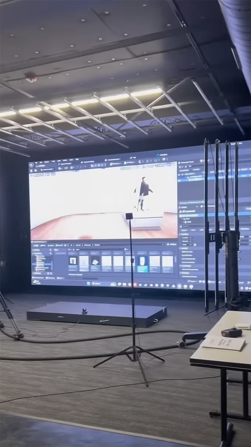 A large screen displays a software interface in a virtual production lab.