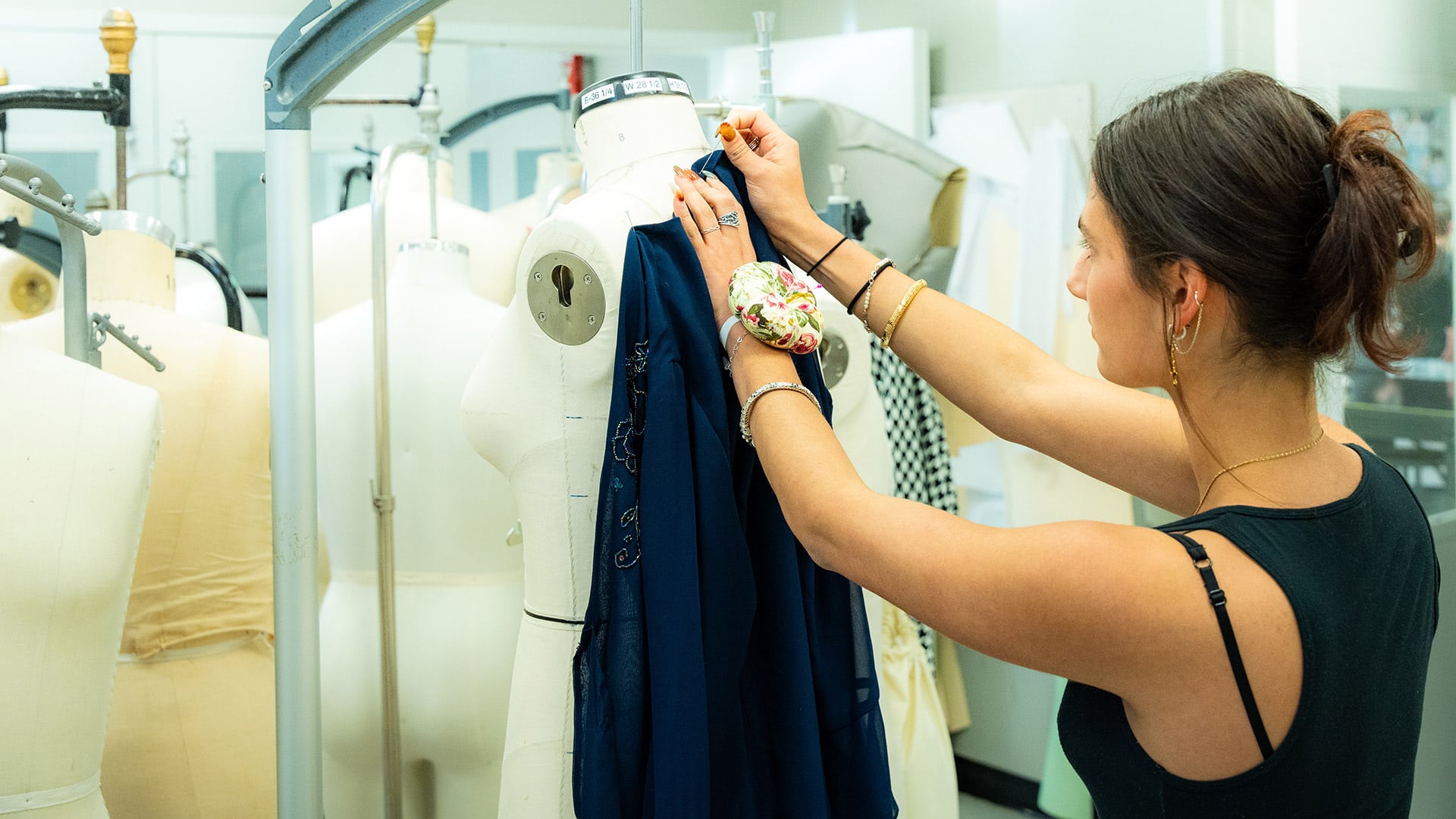 Fashion and textile design student Neely Mallik works to fit a garment to manikin in a workspace in the Wilson College of Textiles.