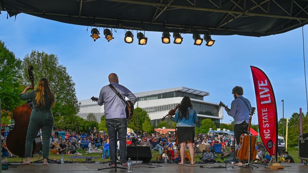 Specators enjoy live music from a bluegrass band at Live at the Lake at Arts NC State at Lake Raleigh.