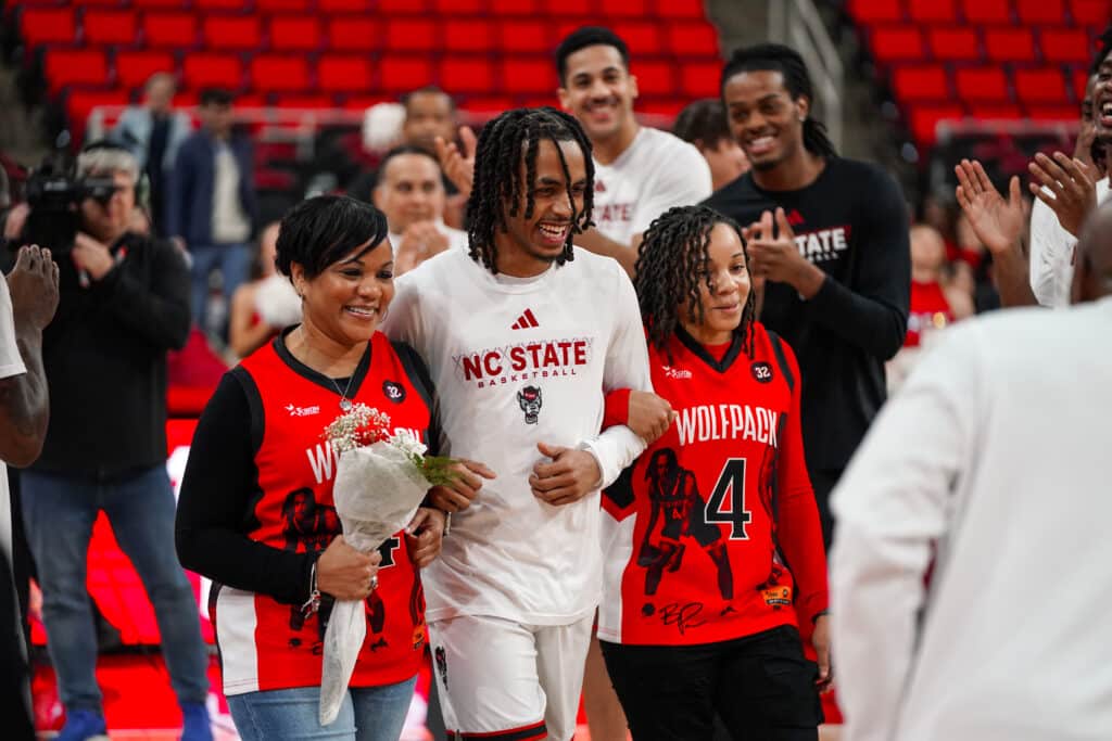 Breon Pass, along with his mother and sister, are applauded as they walk onto the court on Senior Night.