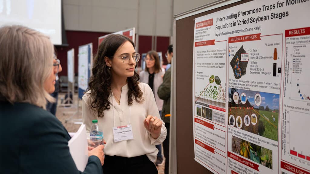 A student discusses their research with the public and faculty judges.