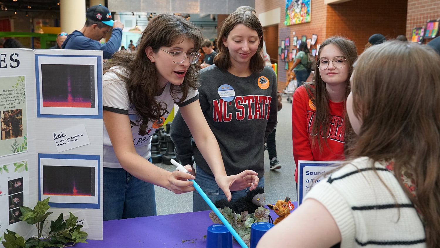 Zoology students lead an activity with a child at their table at the Marbles Kids Museum's Backwards Science Fair