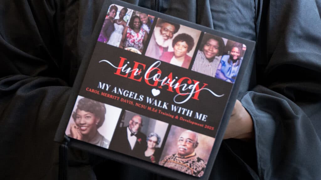Carol Davis' holds her graduation cap, which is covered in photos of loved ones who inspired her.